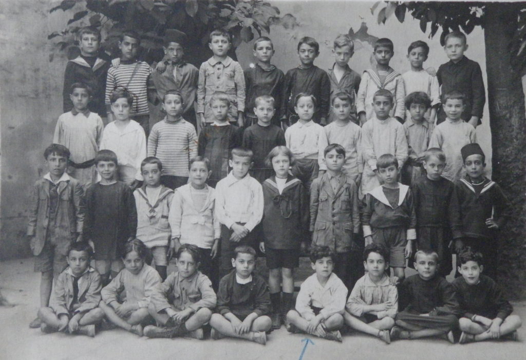 École Mailhes du boulevard Gambetta, Alger, vers 1920. Lucien Hanoun est au troisième rang, second en partant de la gauche. Sa classe compte deux enfants "musulmans", distingués par leur couvre-chef.